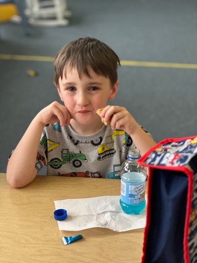 A young boy sitting at his desk on the first day of school.